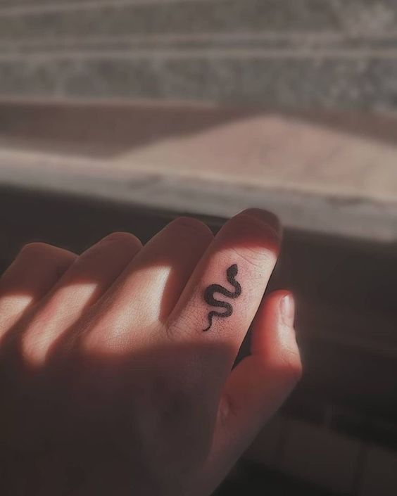 small snake tattoo on finger