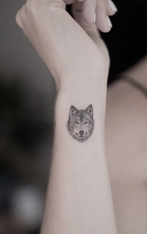 small wolf face tattoo on wrist