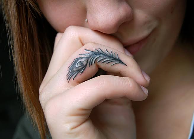 feather tattoo on side finger